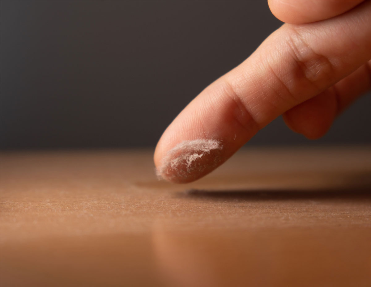 If you run your finger along a baseboard, set of blinds, or shelf, you notice a thin layer of dust or hair on your finger. The dust may be hard to notice on the surface unless you are looking closely.