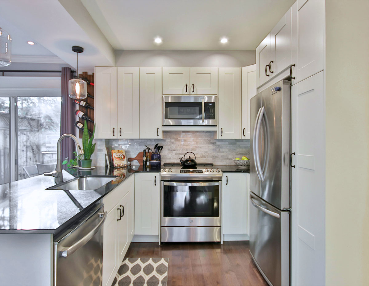 This kitchen belongs to someone who keeps everything neatly tucked away in cabinets or drawers, with only the essentials left out on the countertops.