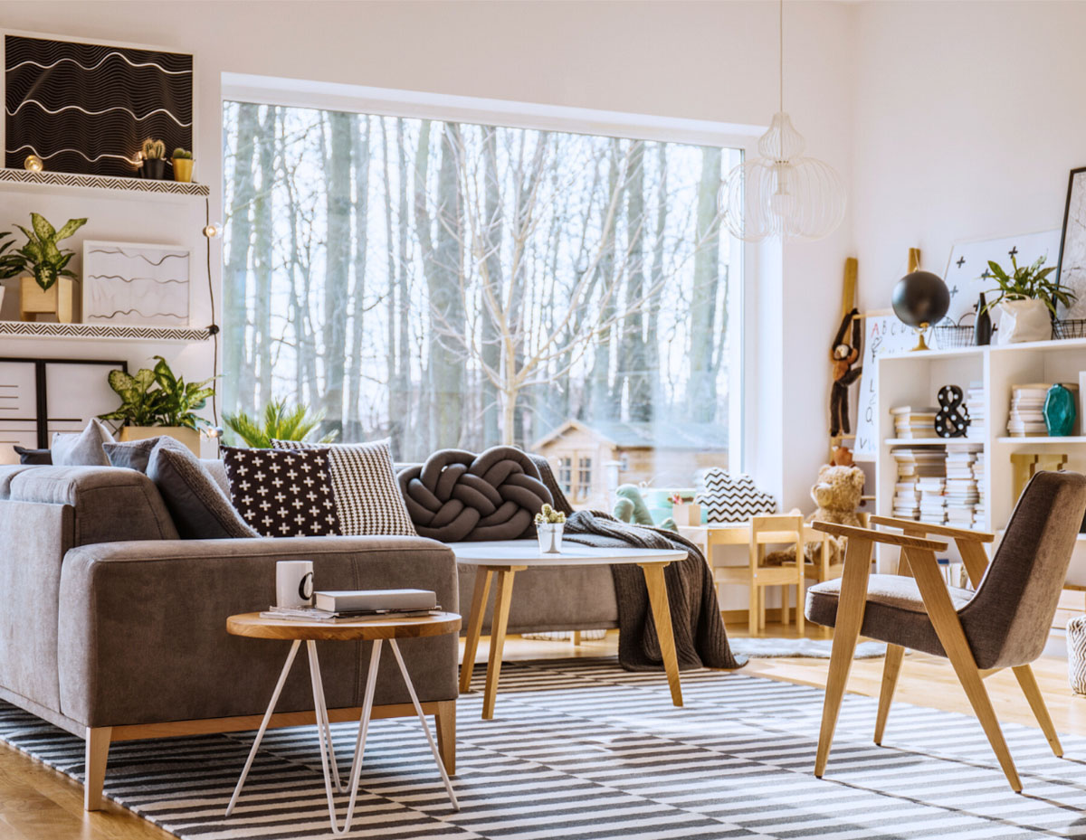 This living room is neat and organized, but filled with decor and items displayed on shelves or mantels. It might belong to a grandparent showcasing cherished knick-knacks and family photos, or someone who enjoys having their books, photos, or decor arranged on display.