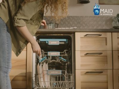a woman is organizing plates in the kitchen cabinet