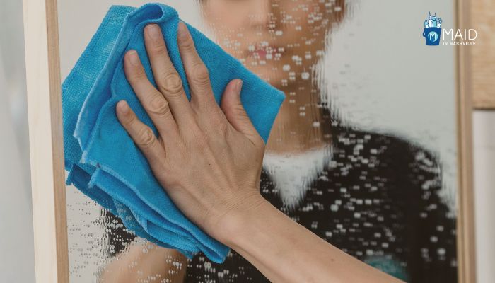 woman is wiping the mirror